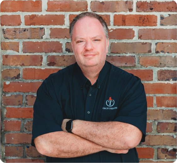 A man in a suit speaks to several other suited individuals in a conference room.